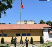 Catarg cu drapel ridicat de militari și cercetași în curtea Școlii Octavian Goga